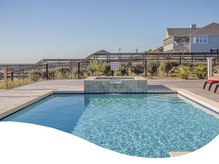 Two people swimming in their backyard swimming pool.